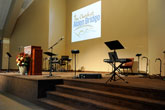 Church interior: showing the musicians' area and lecturn at the front of the building as well as the projection system